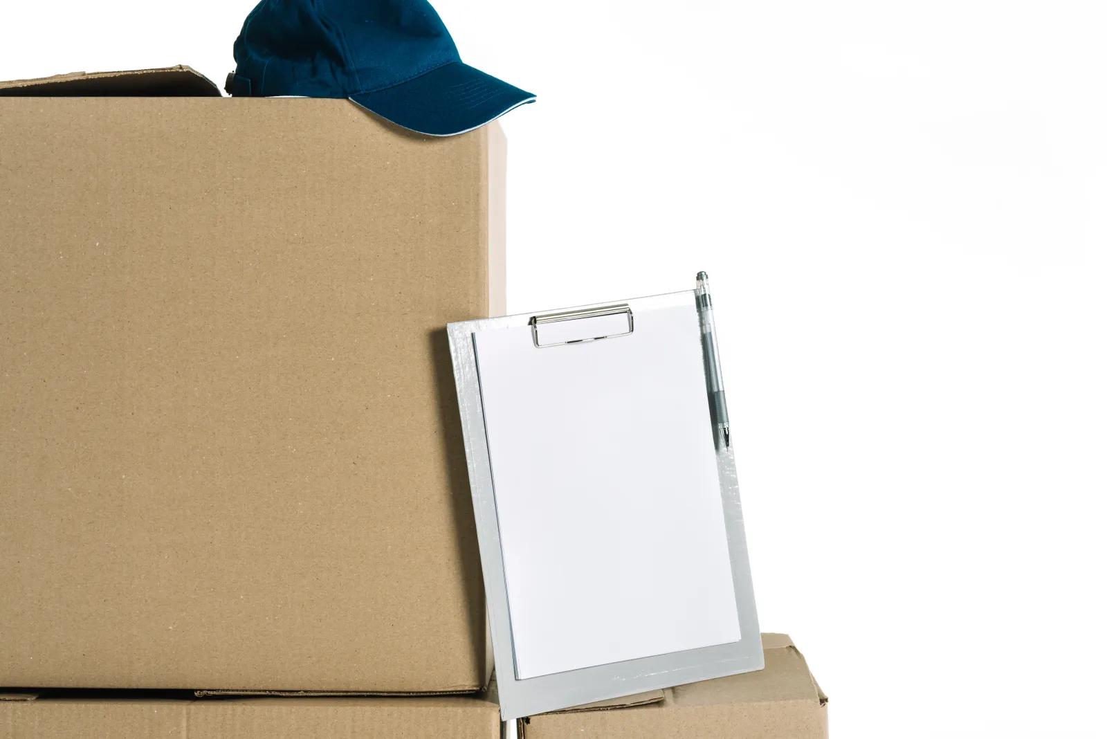 Hand ticking off a printed moving-house checklist on top of a cardboard box
