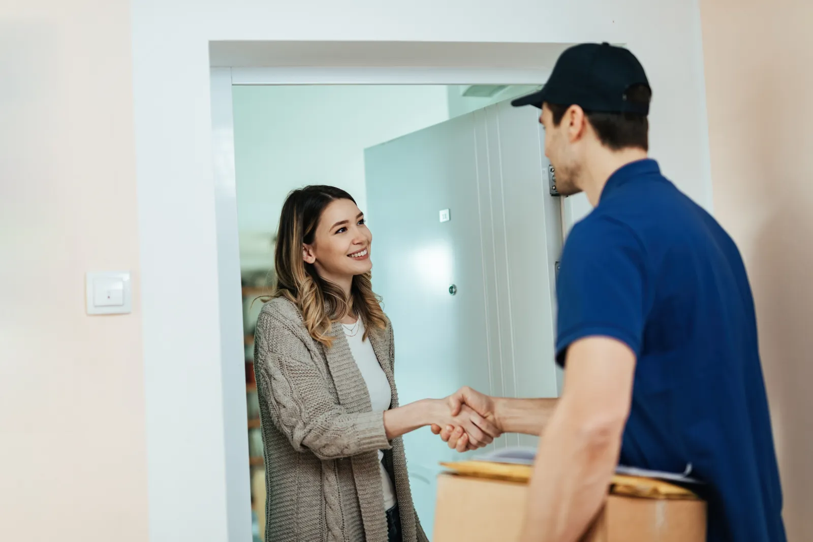 Removals foreman shaking hands with a customer at the front door