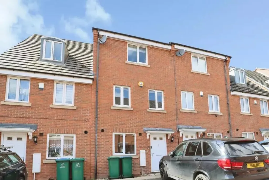Removal team carrying boxes into a modern Coventry townhouse